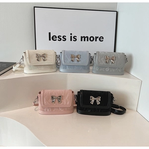 Macro detail of various mini crossbody bags featuring pleated texture and silver bows