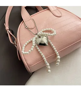 Sac à main rose à motif crocodile avec nœud en perles et pendentif cœur argenté