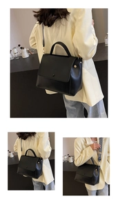 Detail der schwarzen Handtasche mit goldener Hardware und Jacquard-Tragegurt im Café
