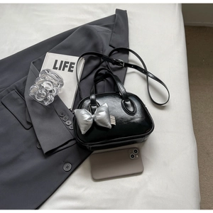 Schwarze Boston-Tasche mit glänzendem Finish, silbernem Schleifenanhänger und Tragegriffen