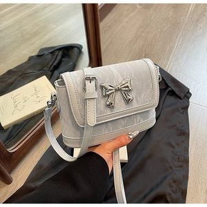 Detailed close-up of light gray crossbody bag with marble print and silver butterfly buckle