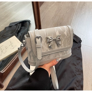 Detail shot of a silver butterfly crossbody bag featuring a marbled pleated texture surface