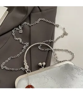 Detailed macro view of retro silver embroidery purse with floral pattern and metal chain
