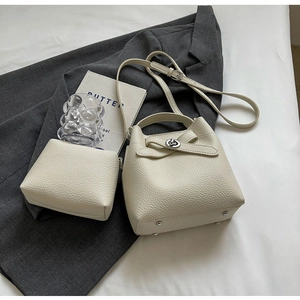 Detailansicht der cremefarbenen Beuteltasche aus Leder mit Lychee-Muster und Innentasche