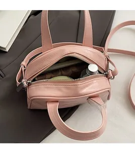 Détail d'un sac à main rose texture crocodile montrant sa grande capacité intérieure