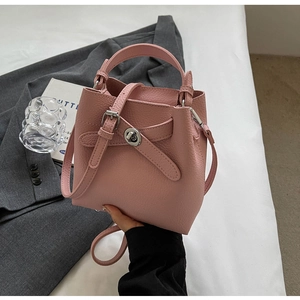 Detail der rosa Bucket Bag aus genarbtem Leder mit dekorativer Schnalle und Drehverschluss