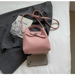 Detail der rosa Bucket Bag aus genarbtem Leder mit Schleife und Metalldrehverschluss