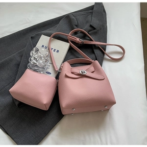 Rosa Eimertasche aus genarbtem Leder mit Drehverschluss und silbernen Metallnieten im Detail