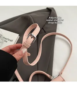 Detail of adjustable silver buckle and pink leather strap on a stylish handbag
