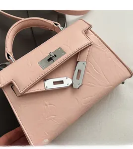 Close-up of pink textured leather bag featuring a silver metal twist lock and handle