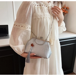 Detail of silver silk jacquard chain bag with vintage frame clasp and side tassel