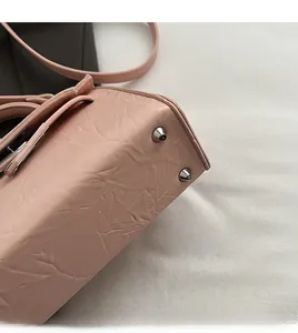 Close-up of pink leather handbag base showing protective silver metal bottom studs