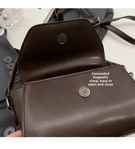 Detailed close-up of dark brown leather handbag with hidden magnetic snap closures