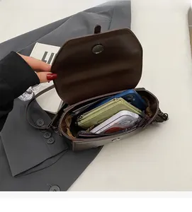 Top-down view of a dark brown leather crossbody bag with multiple interior compartments