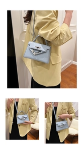 Close-up of light blue textured leather handbag featuring silver hardware and rotary lock