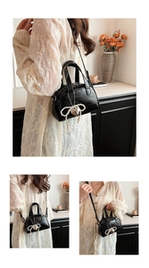 Détail du sac à main noir avec pendentif nœud en perles et texture en cuir lisse brillant