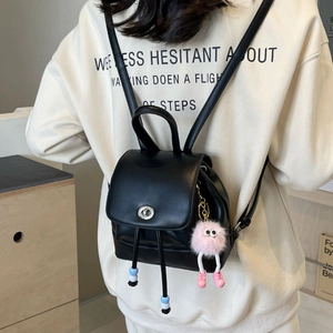 Mini zaino chic in pelle nera con chiusura a scatto e ciondolo di peluche rosa
