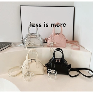 Quatre mini sacs bandoulière en argent, rose, beige et noir avec charms cœur perlé