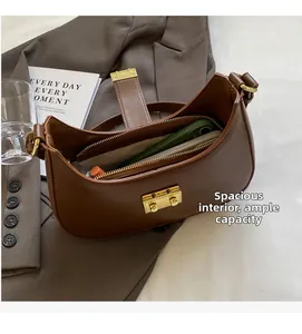Détail du compartiment intérieur spacieux du sac besace en cuir marron avec boucle dorée