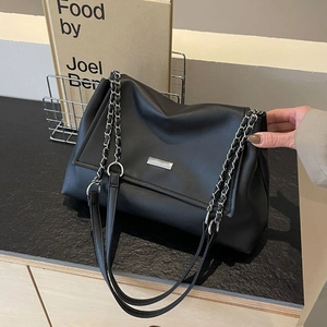 Minimalist black faux leather tote bag with silver chain strap and metal logo plate