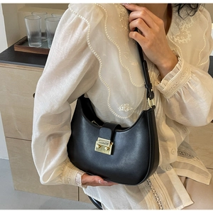 Détail d'un sac hobo noir avec une boucle dorée et une bandoulière réglable pratique