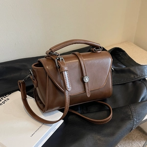 Retro brown PU leather handbag with metal buckle and adjustable strap in lifestyle setting