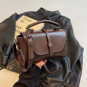 Retro dark brown crossbody bag with metal buckle and top handle in a vintage style