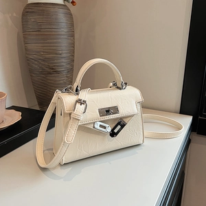 Chic beige pleated Kelly bag with silver twist lock and crossbody strap for women
