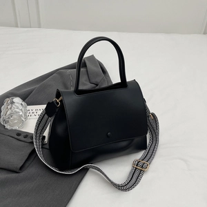 Mattschwarze Damenhandtasche mit gemustertem Webriemen in eleganter Draufsicht