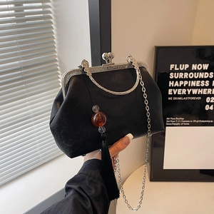 Retro black kiss-lock handbag with silver engraved metal frame and long tassel detail