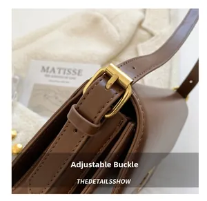 Close-up of vintage gold buckle and textured brown leather on an adjustable shoulder bag