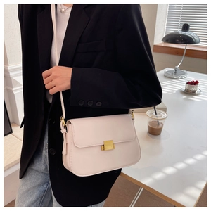 Detail of cream white PU leather square bag with golden buckle and slim strap
