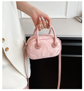 Detailed view of pink marble texture handbag with heart-shaped handle attachments