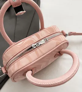 Detail of pink marble pattern handbag showing silver zipper and handle stitching