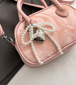 Detail of pink marble pattern bag with pearl strap and heart metal charm