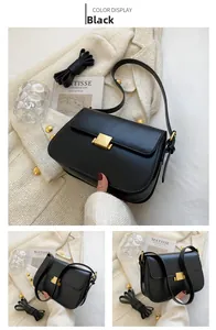 Close-up of black crossbody bag featuring a gold square buckle and adjustable straps