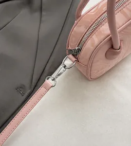 Detail of pink marble textured handbag showing silver metal zipper and detachable hook