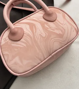 Detail of pink marble pattern handbag with soft leather texture and smooth handles