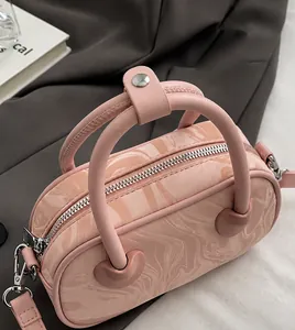 Detail view of pink marble pattern handbag with dual handles and heart shaped hardware