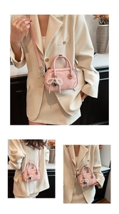 Detail of pink marble textured handbag with pearl bow charm and heart-shaped handle joints