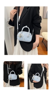 Detail of light blue mini handbag with pearl bow charm and silver heart pendant