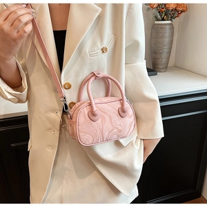 Detail of pink marble pattern handbag with heart-shaped handle stitching on cream blazer