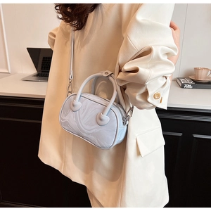Detail of grey marble textured handbag with heart-shaped handle connectors and shoulder strap