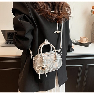 Detail of silver marble textured handbag with pearl bow charm and heart metal hardware