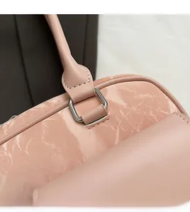 Detail of pink faux marble leather stitching and silver D-ring buckle on shoulder bag