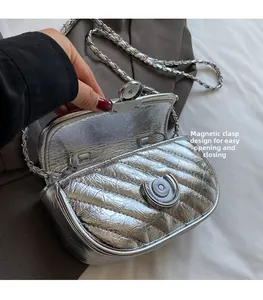 Detail of silver quilted chain bag featuring a magnetic closure for easy opening and closing