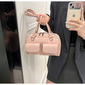 Detail of pink PU leather handbag with dual front pockets and silver metal zippers