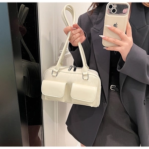 Detail of white glossy baguette bag with double pockets and silver metal zippers