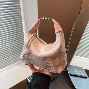Detail of pink satin hobo bag featuring white landscape embroidery and bead tassel