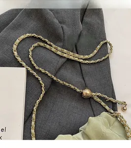 Detail of light green woven chain strap with adjustable gold quilted metal ball slider